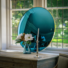 Load image into Gallery viewer, A Blue Round Convex Mirror propped on a wooden sideboard and against a large bay window. A vase of flowers and candle stick is placed in front of the mirror.