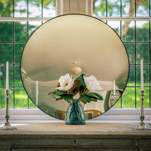 Load image into Gallery viewer, A Silver Round Convex Mirror propped on a sideboard which sites in front of a bay window
